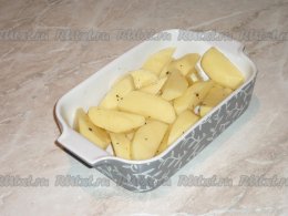 Картошку и морковь очистить и вымыть холодной водой. Картофель нарезать крупными дольками, а морковь - брусочками. Жаропрочную форму смазать растительным маслом и выложить нарезанную картошку.